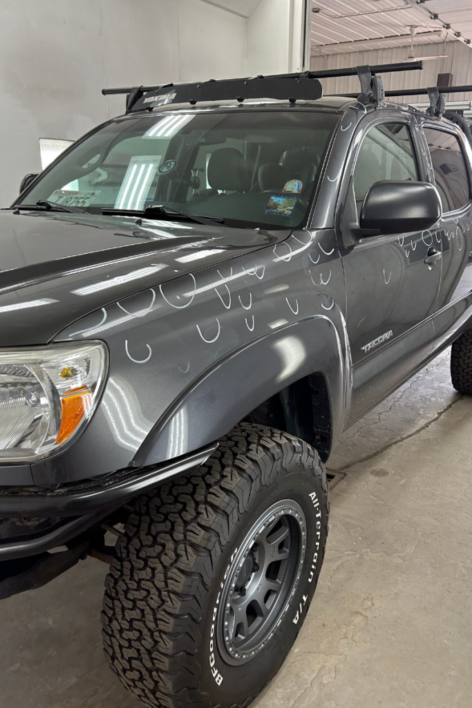 a black truck with hail dents on it